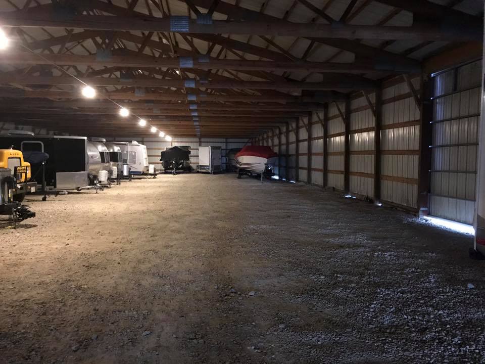 A large barn with many vehicles parked in it.