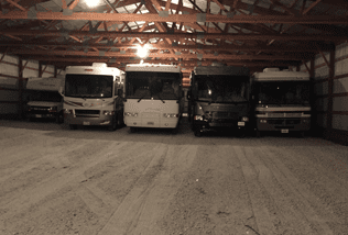 A group of buses parked in a parking lot.