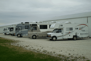 A row of recreational vehicles parked in the sand.